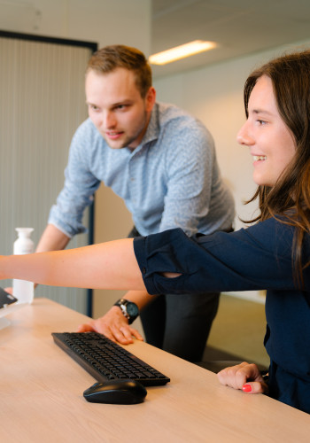 Collega wijst naar beeldscherm